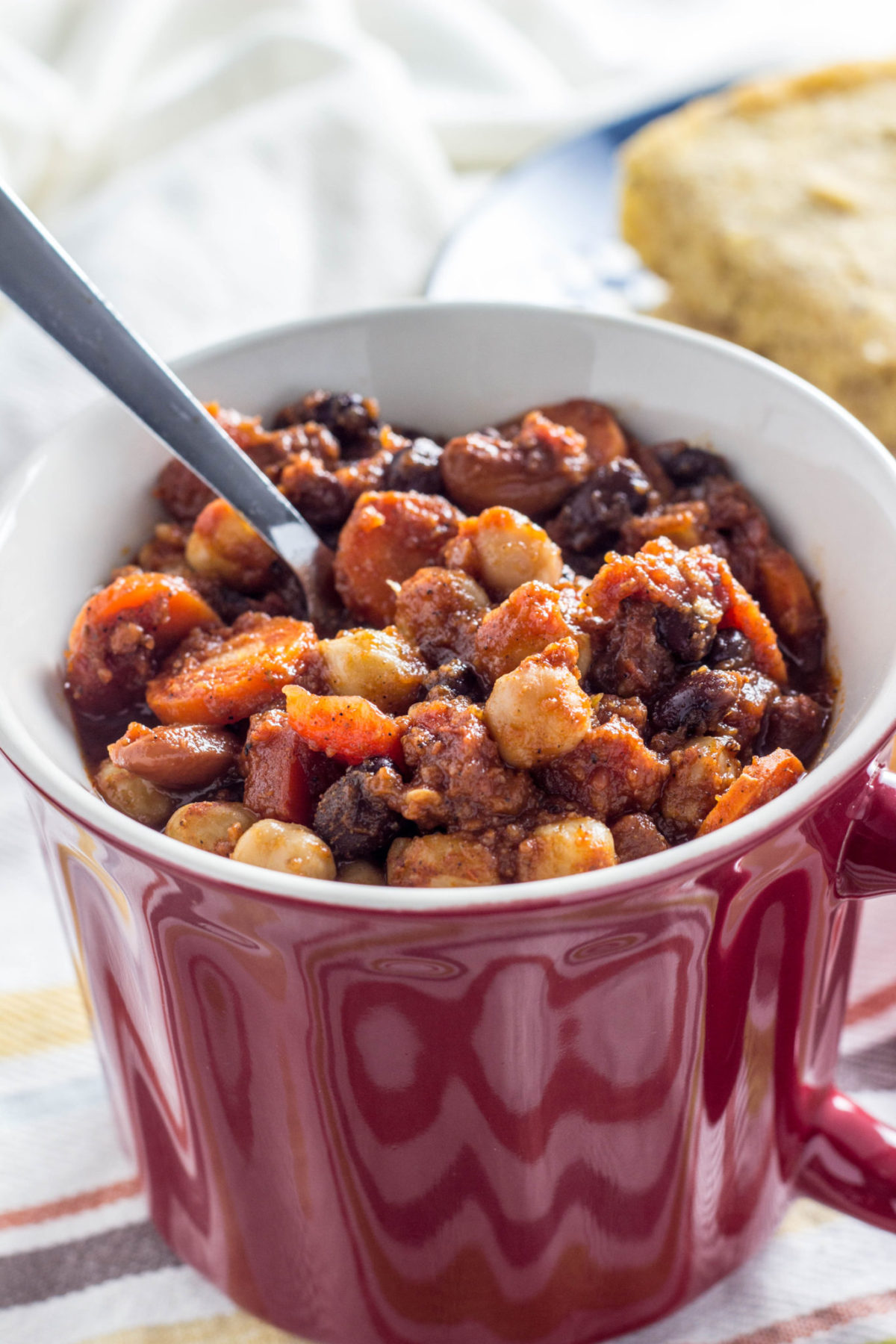 Side view close up of chili in mug with a spoon. 