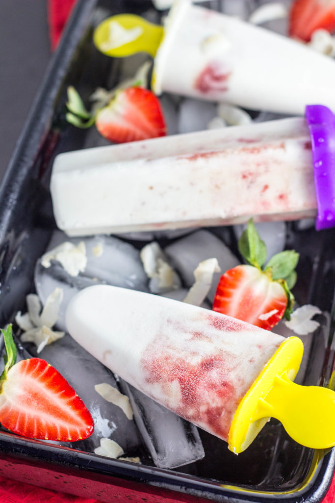Strawberry Coconut Cream Pops-Creamy coconut swirled with a simple strawberry puree for a delicious 3 ingredient frozen treat. No artificial flavorings or coloring and sweetened with maple syrup so this is a sweet treat you can feel good about.