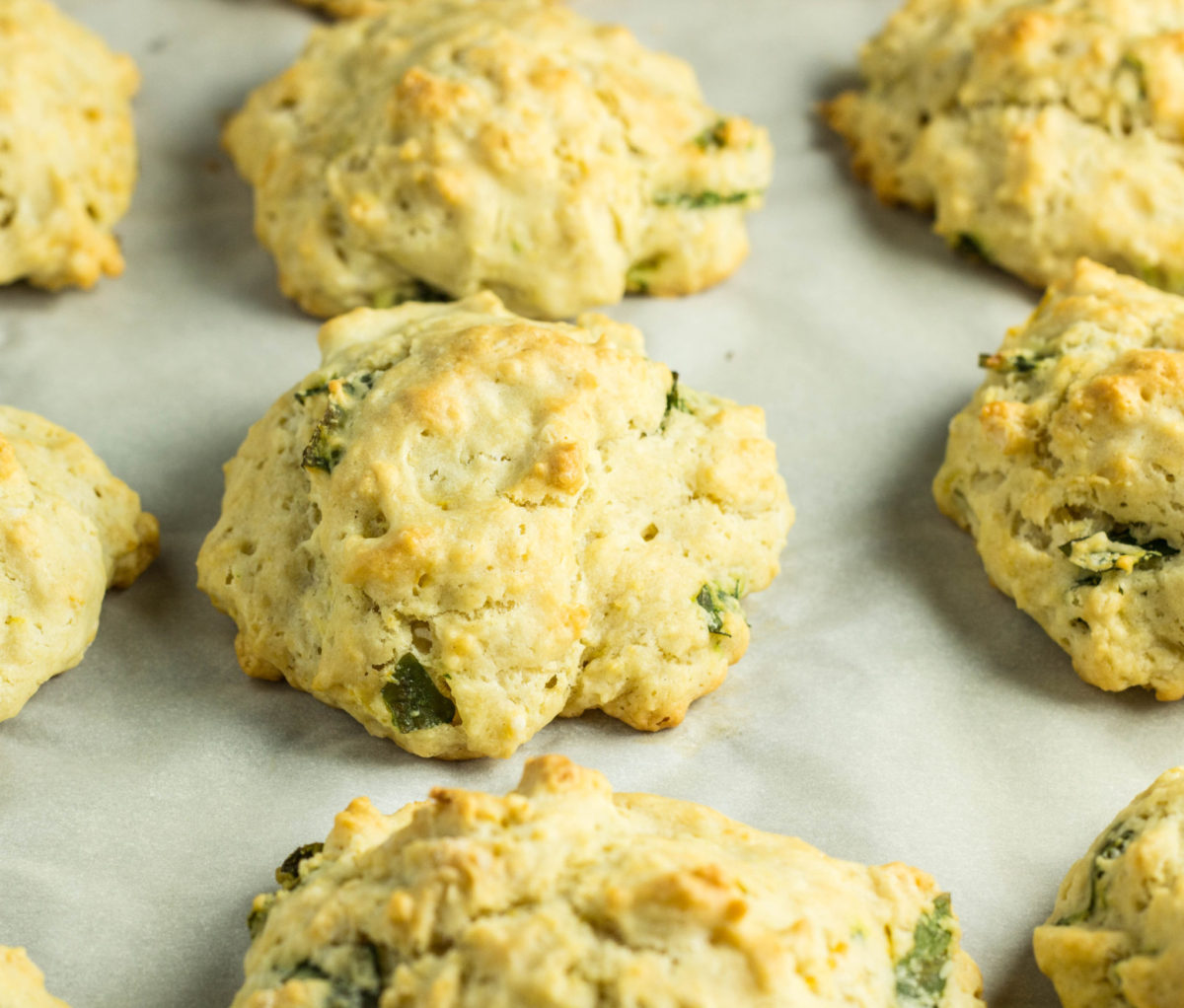 Lemon Basil Drop Biscuits on parchment lined baking sheet. 