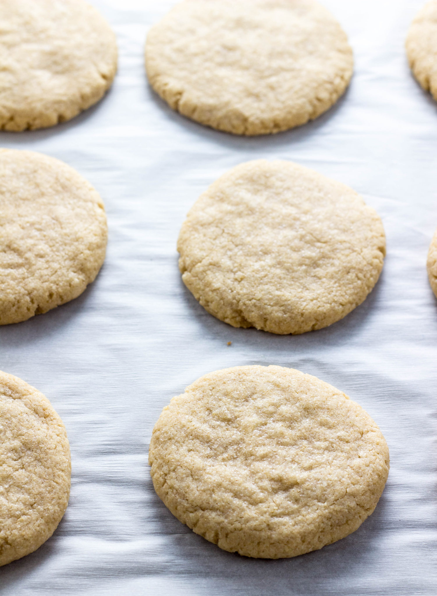 Easy Vegan Coconut Oil Sugar Cookies on a parchment lined baking sheet. 