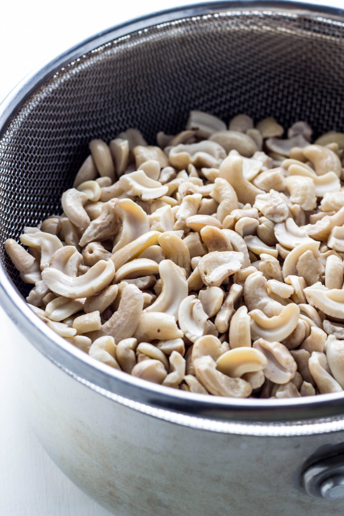 Cashews in a metal strainer.