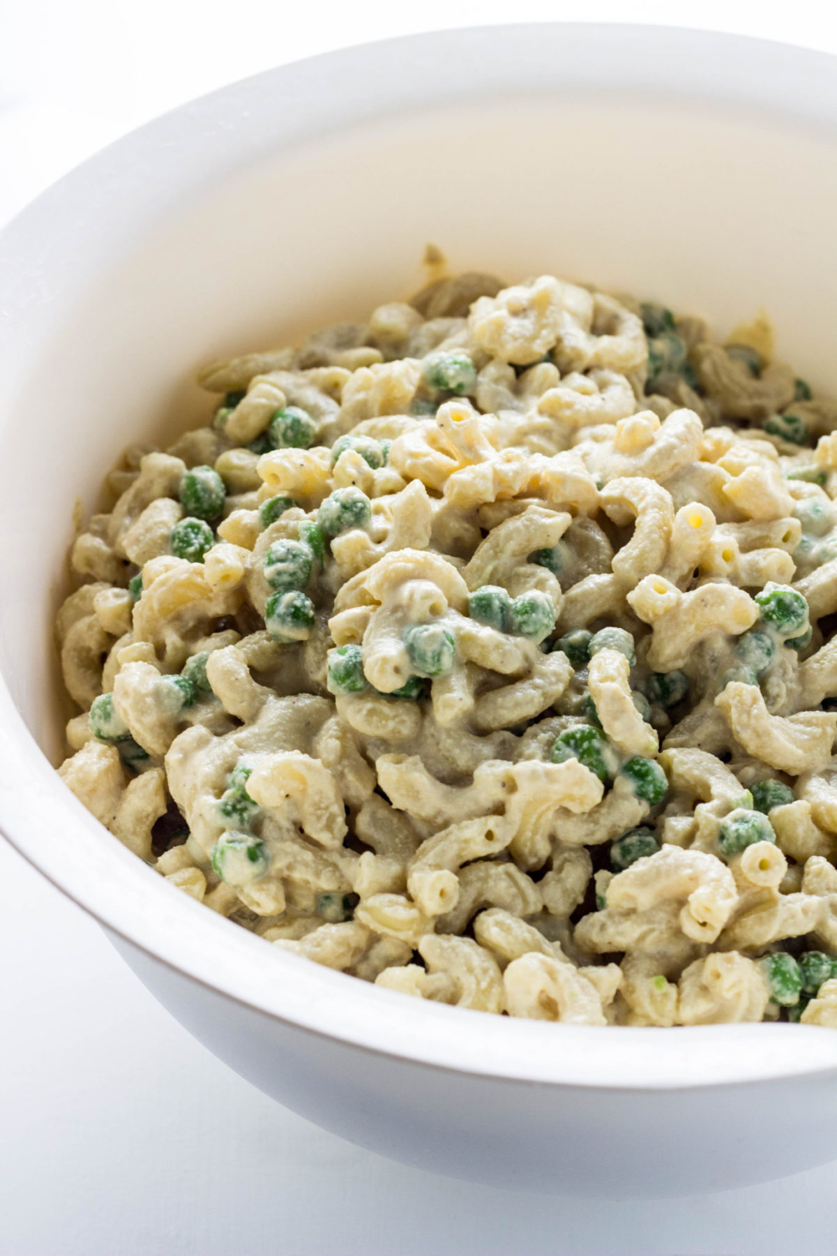 Vegan Cashew Mac 'n Cheese with Peas in a white bowl. 