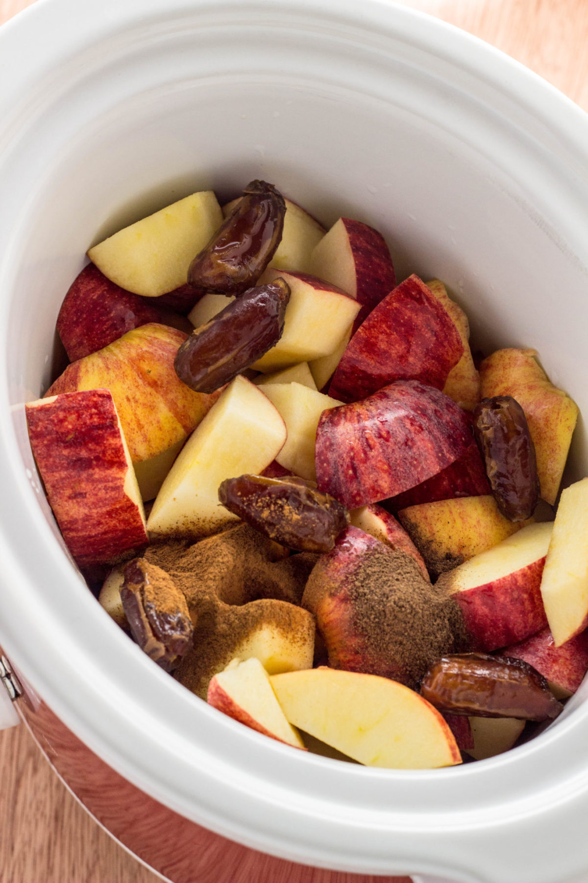 Apples and dates in slow cooker before cooking. 