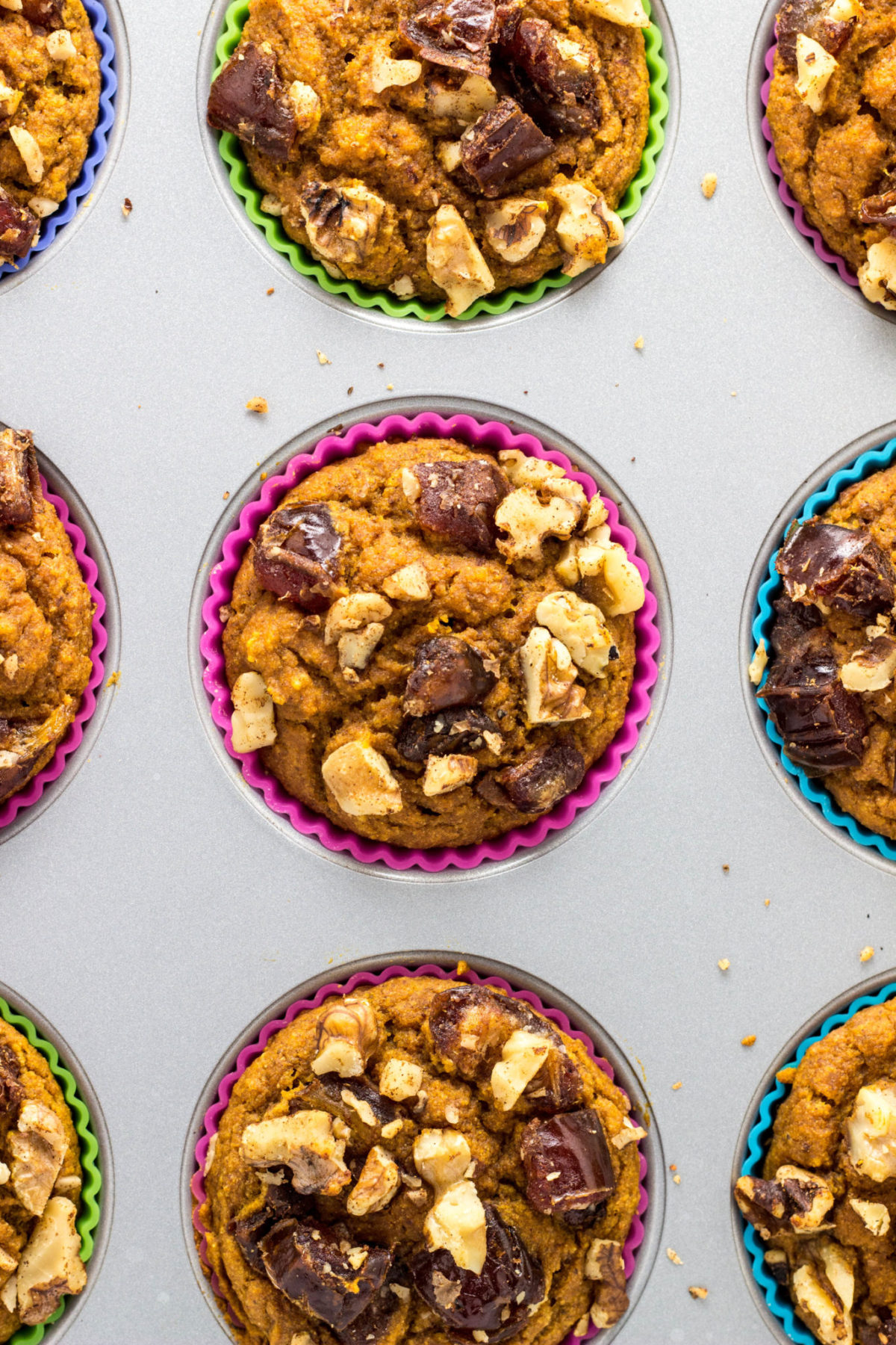 Top view of Vegan Date & Nut Crumble Pumpkin Muffins in a muffin pan. 