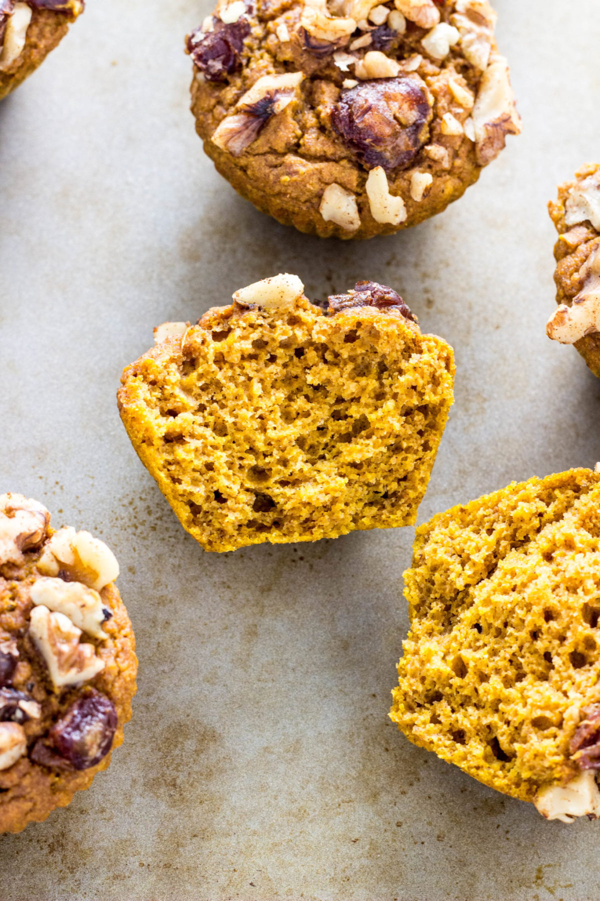 Vegan Date & Nut Crumble Pumpkin Muffin cut in half to show inside texture. 