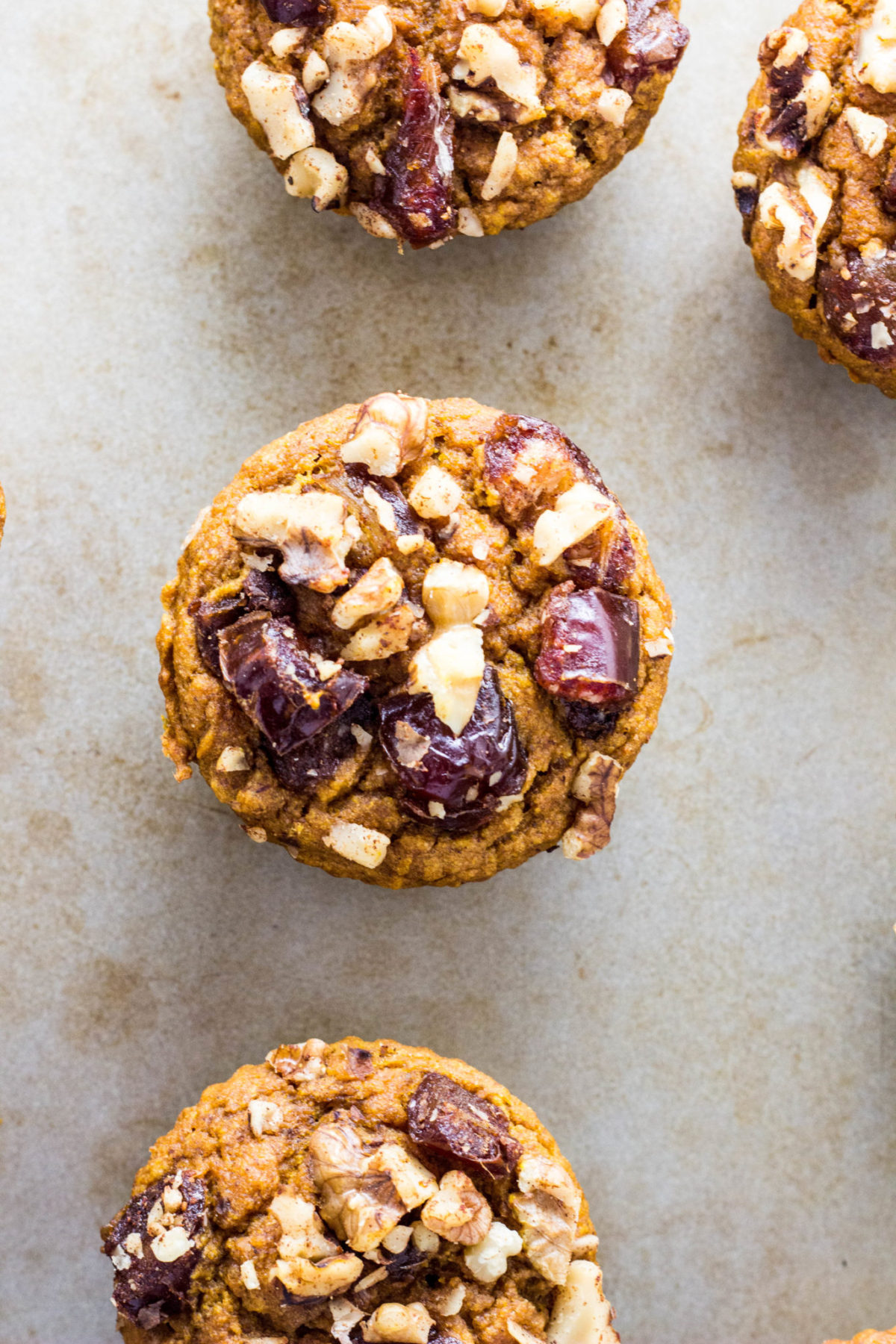 Close up top view of Vegan Date & Nut Crumble Pumpkin Muffin. 