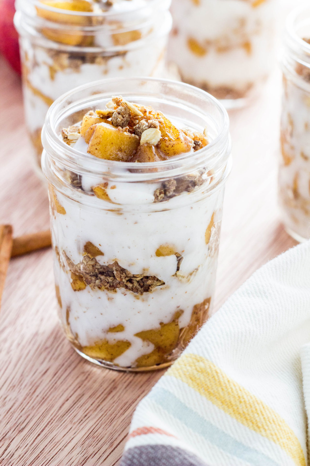 Close up side view of Vegan Sautéed Apple Yogurt Parfait in a clear jar. 