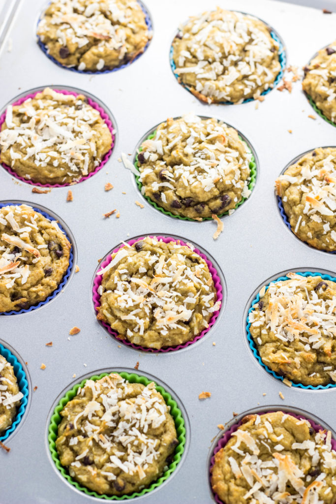 Freshly baked muffins with toasted coconut on top still in the muffin pan. 