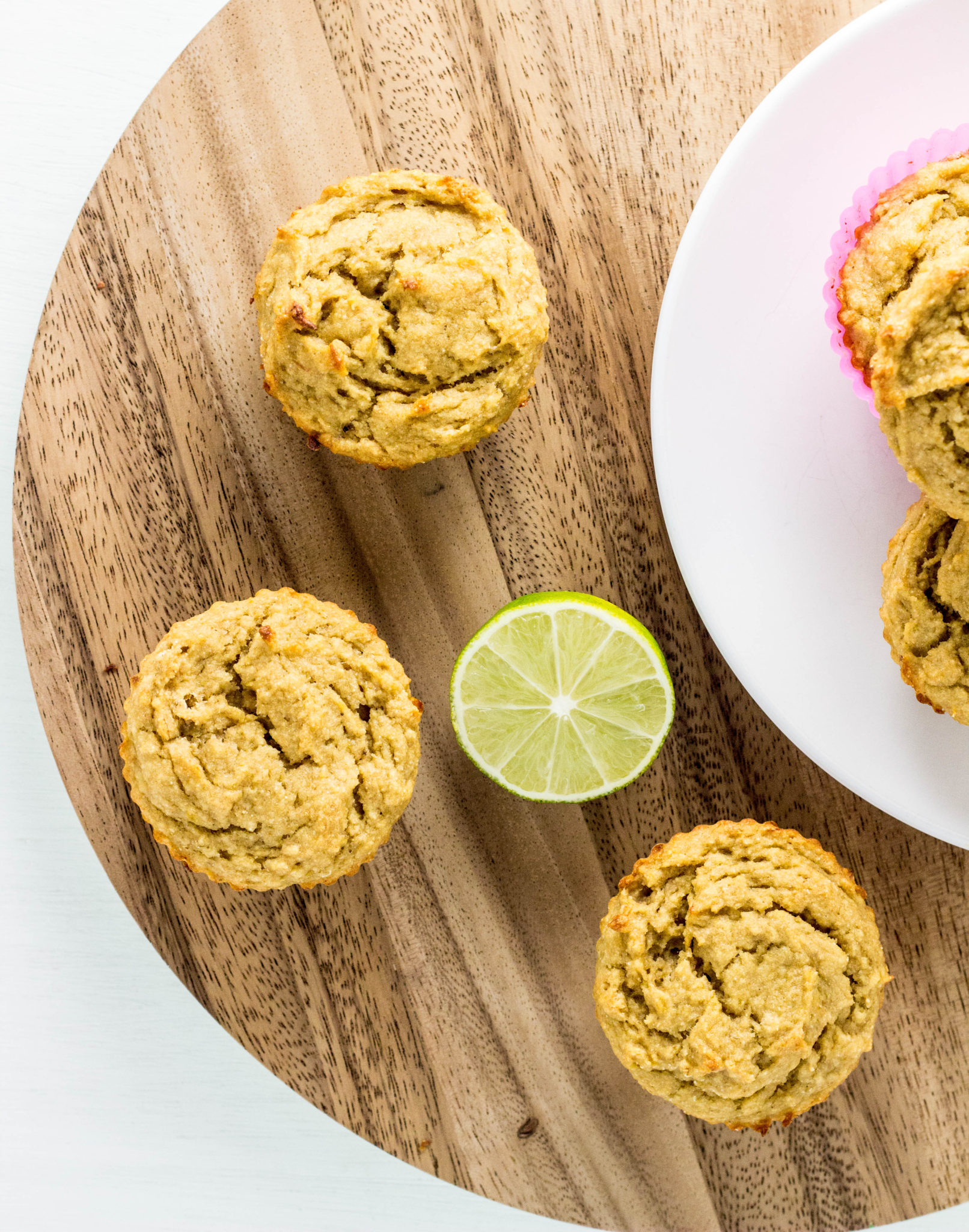 Top view of Vegan Lime Avocado Muffin on a round wooden cutting board with a cut lime.