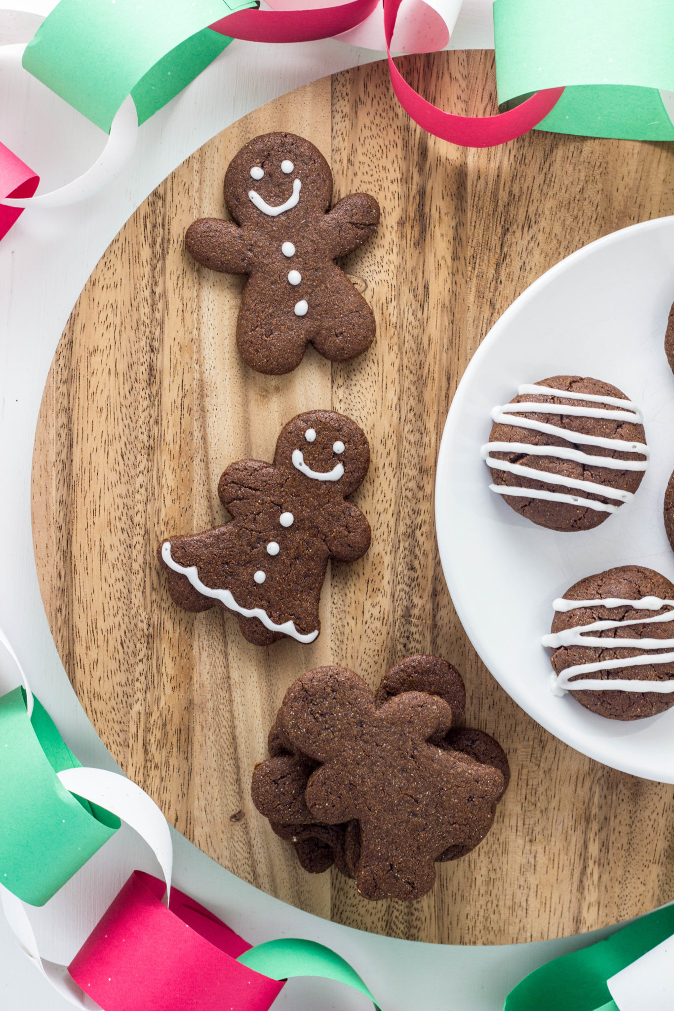 Top view of decorated Vegan Gingerbread  Cookies on a round wooden board.