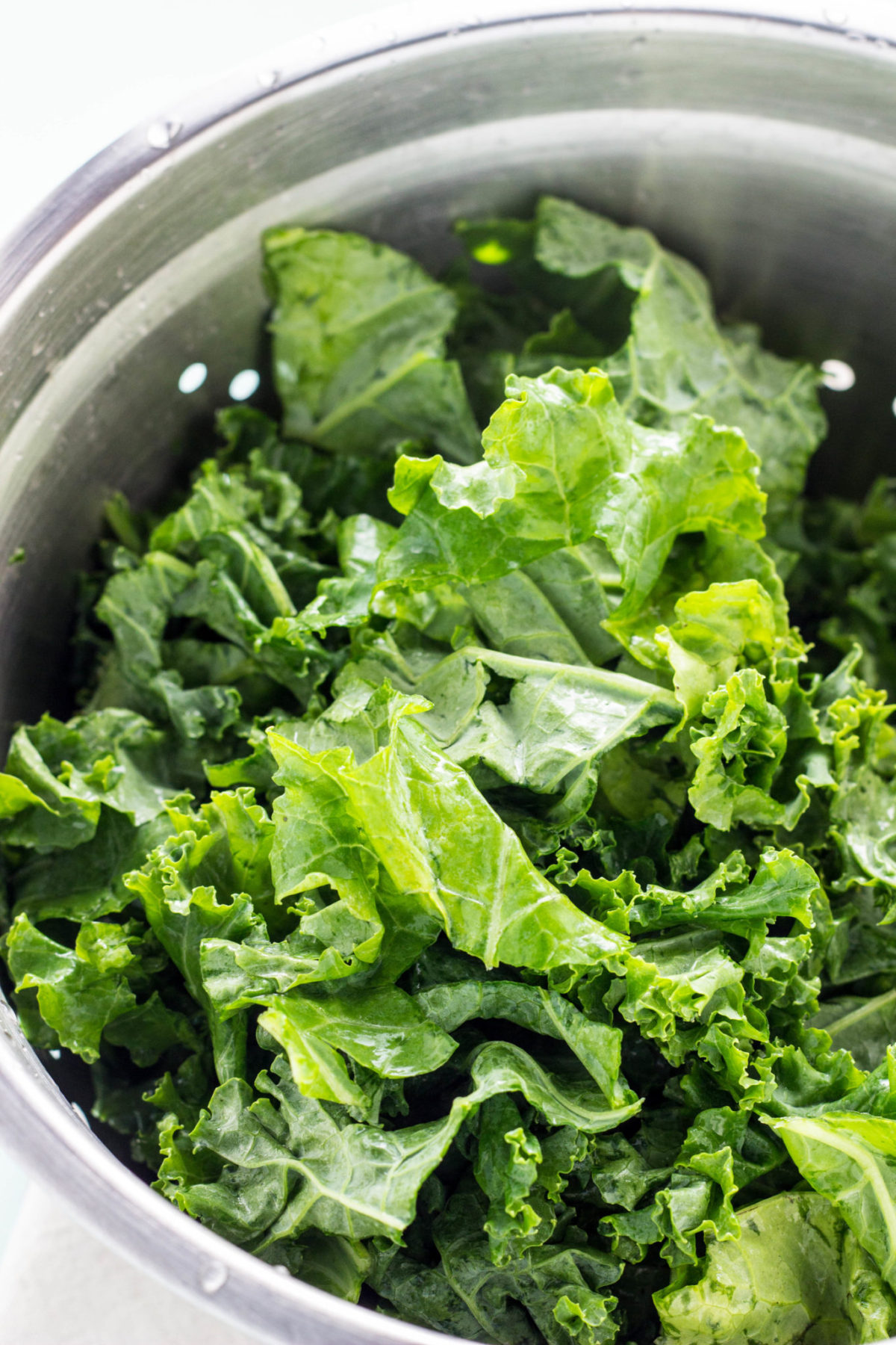 Close up of kale in a metal colander. 