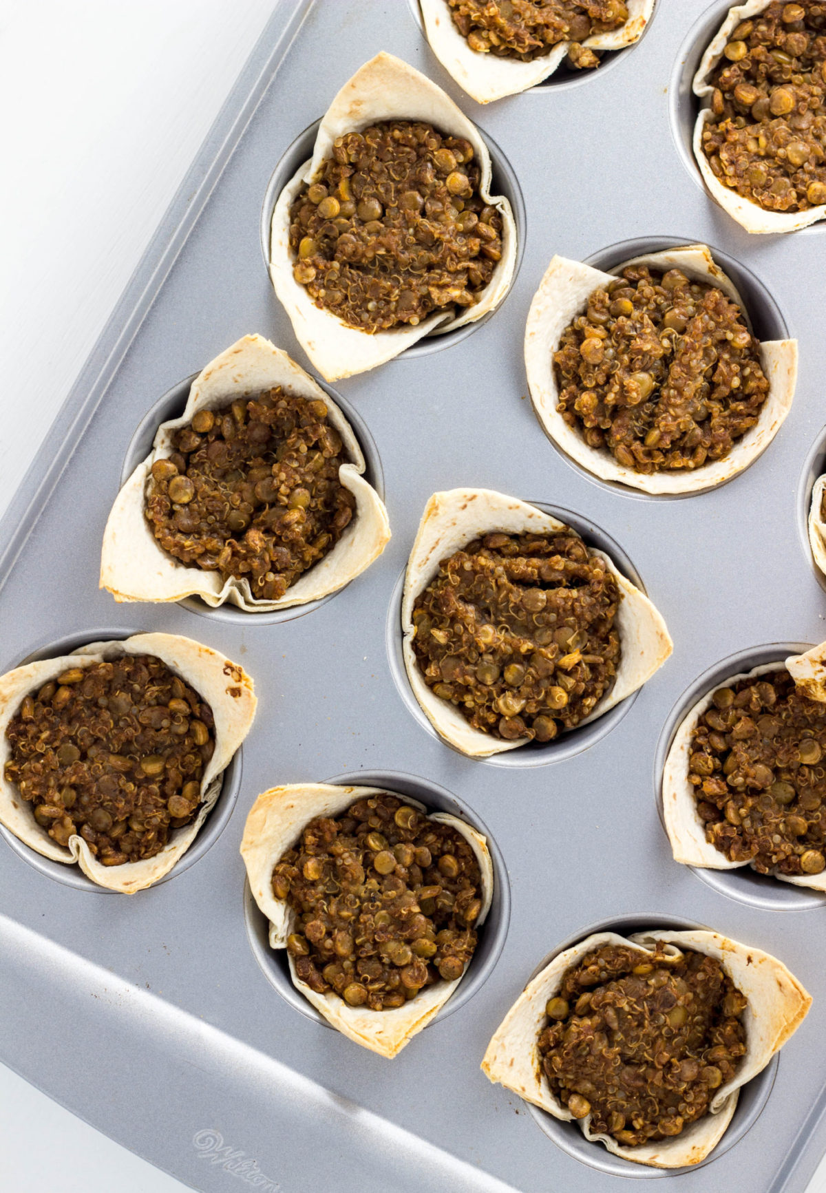 Top view of Lentil Quinoa Taco Cups in muffin pan after baking. 
