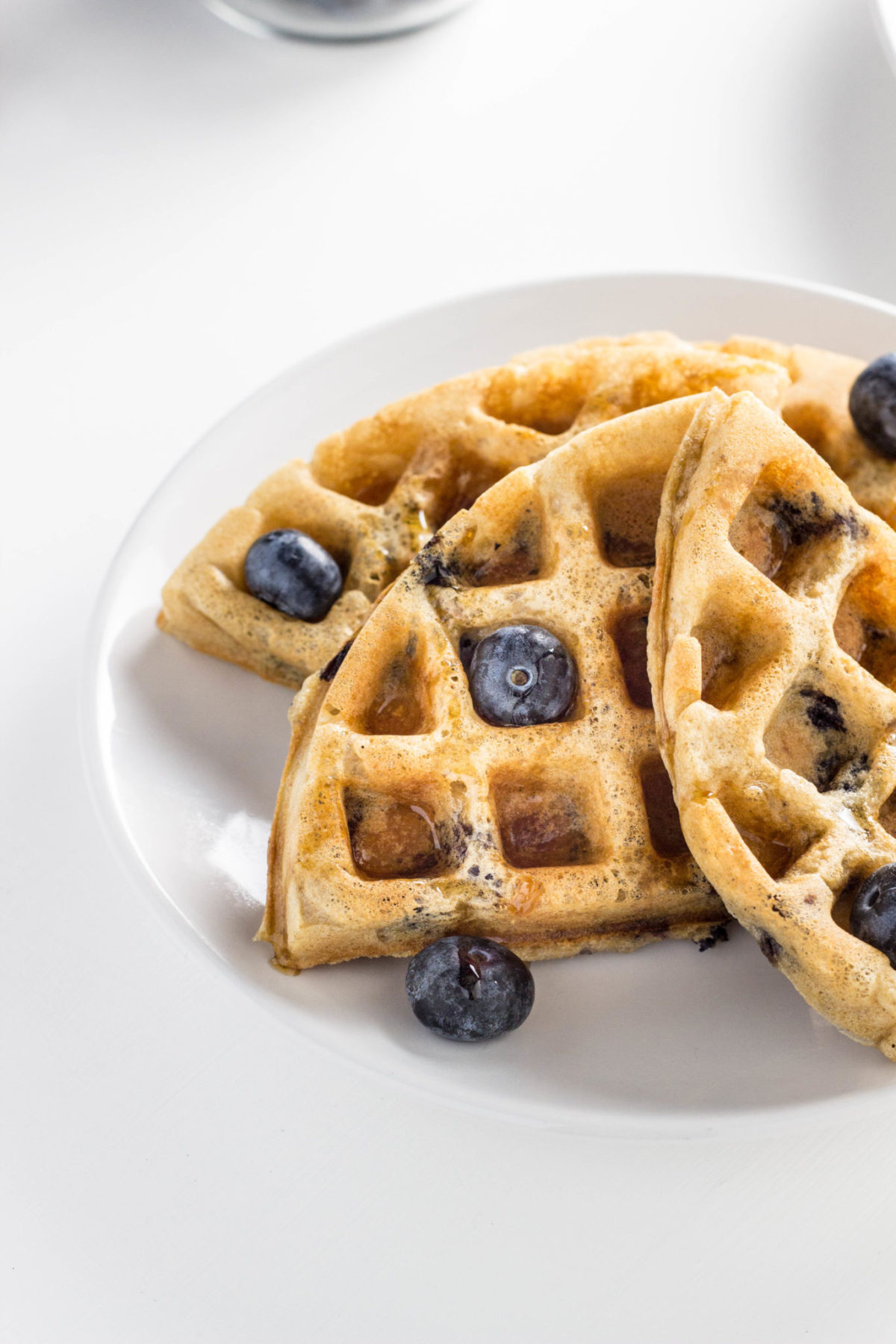 Close up side view of waffles with fresh blueberries.