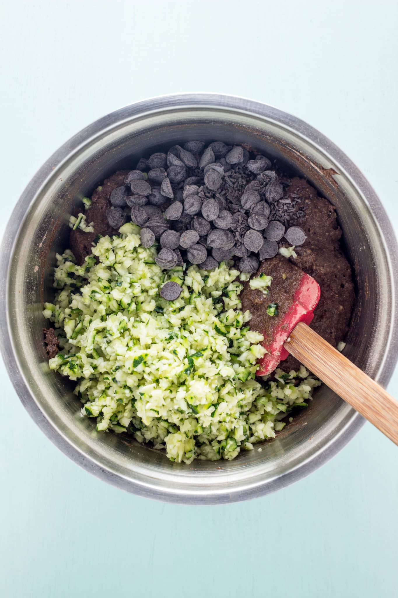 Overhead shot of batter with grated zucchini and chocolate chips before folding in.