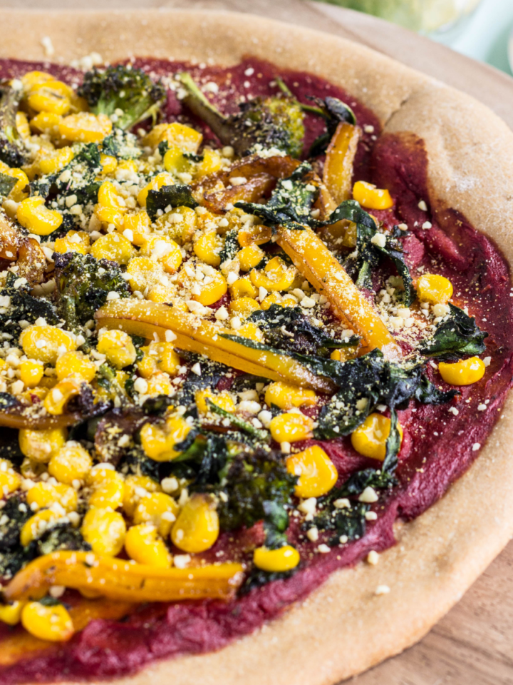 Close up side view of Whole Wheat Yeast Free Pizza Crust with tomato sauce and vegetables.
