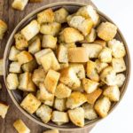 Top view of Simple Vegan Croutons in a bowl on a wood board.