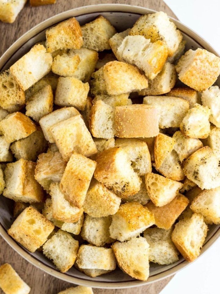 Top view of Simple Vegan Croutons in a bowl on a wood board.