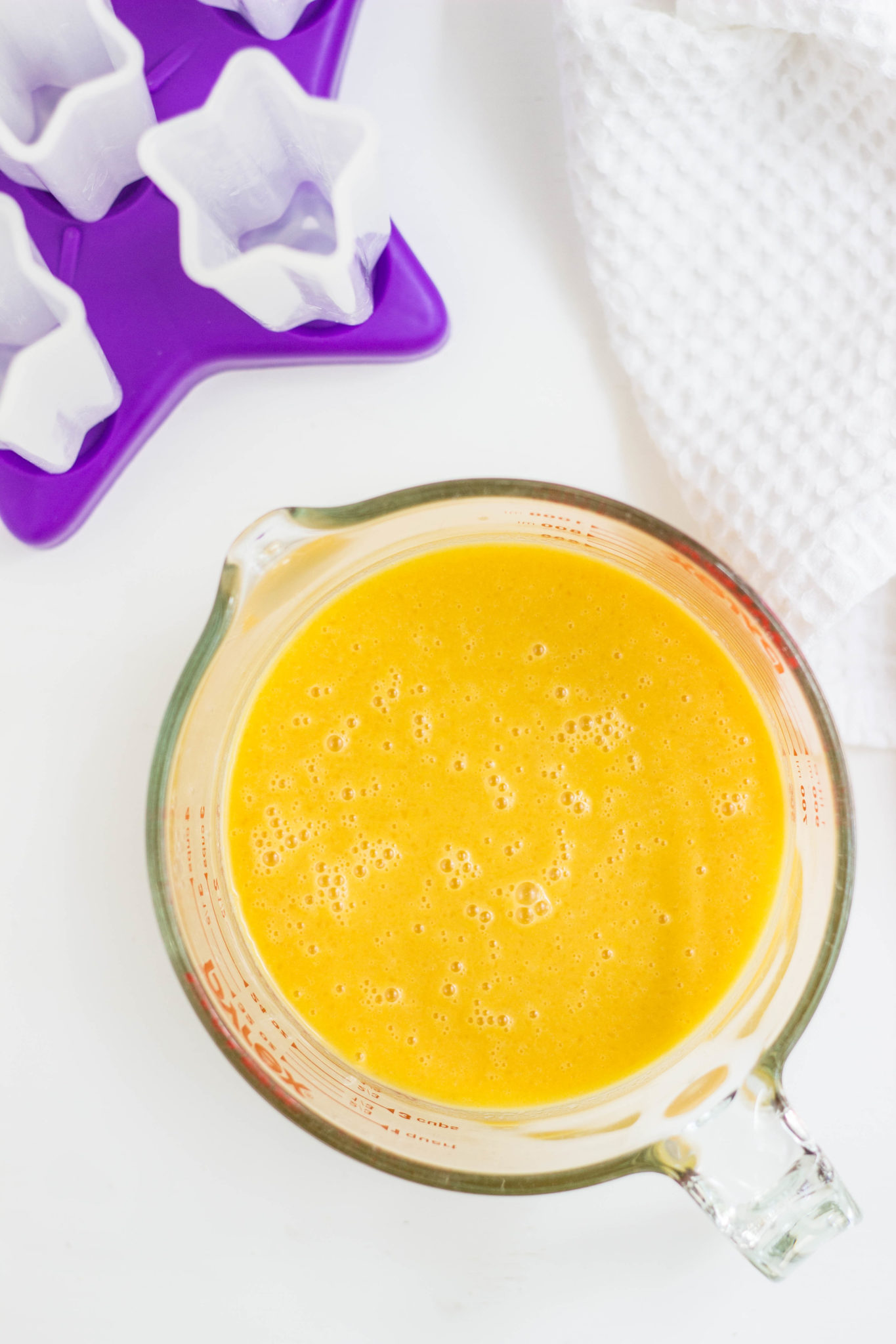 Overhead view of a measuring cup filled with blended fruit mixture. 
