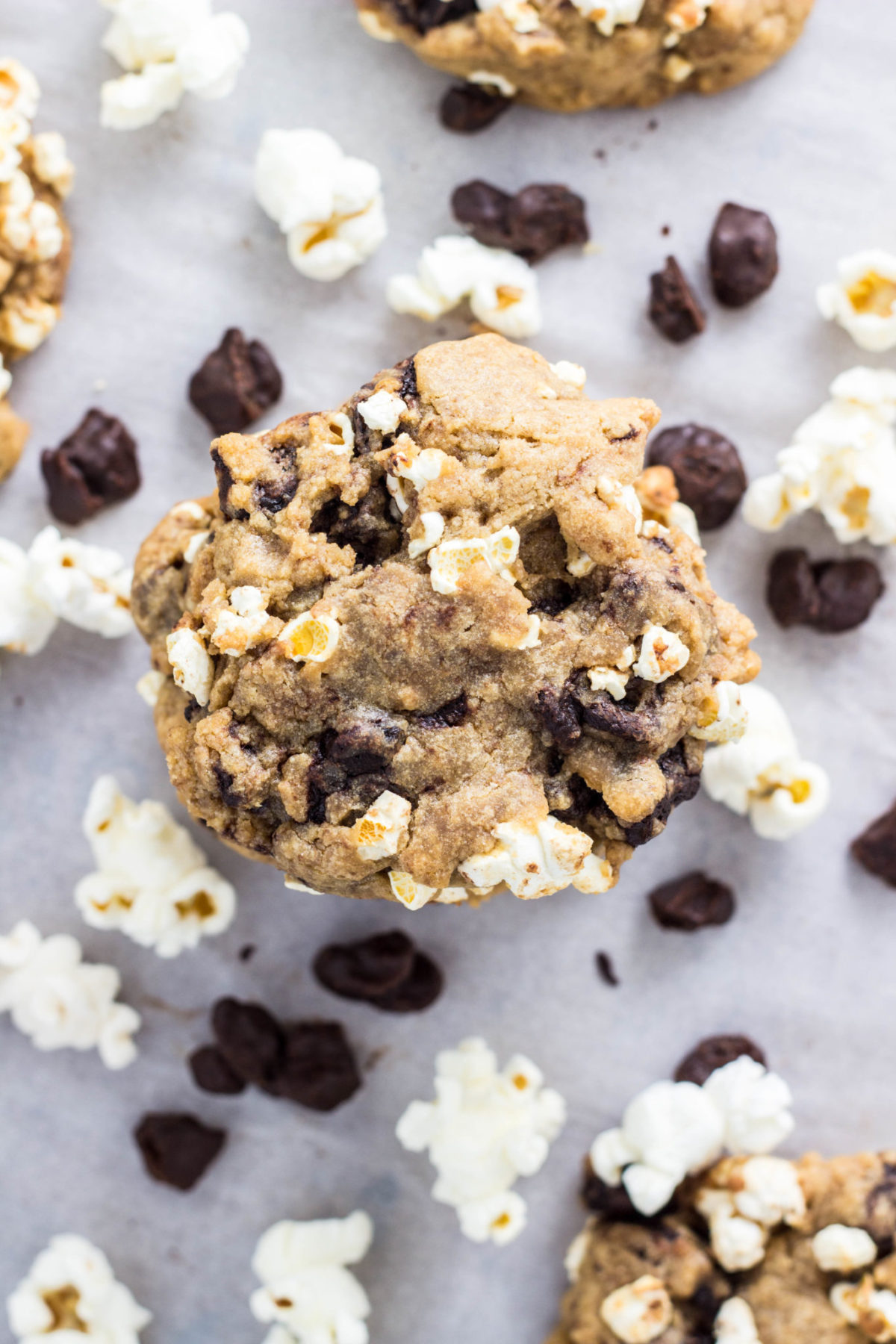 Close up top view of Vegan Movie Snack cookies with popcorn and chocolate covered raisins surrounding. 