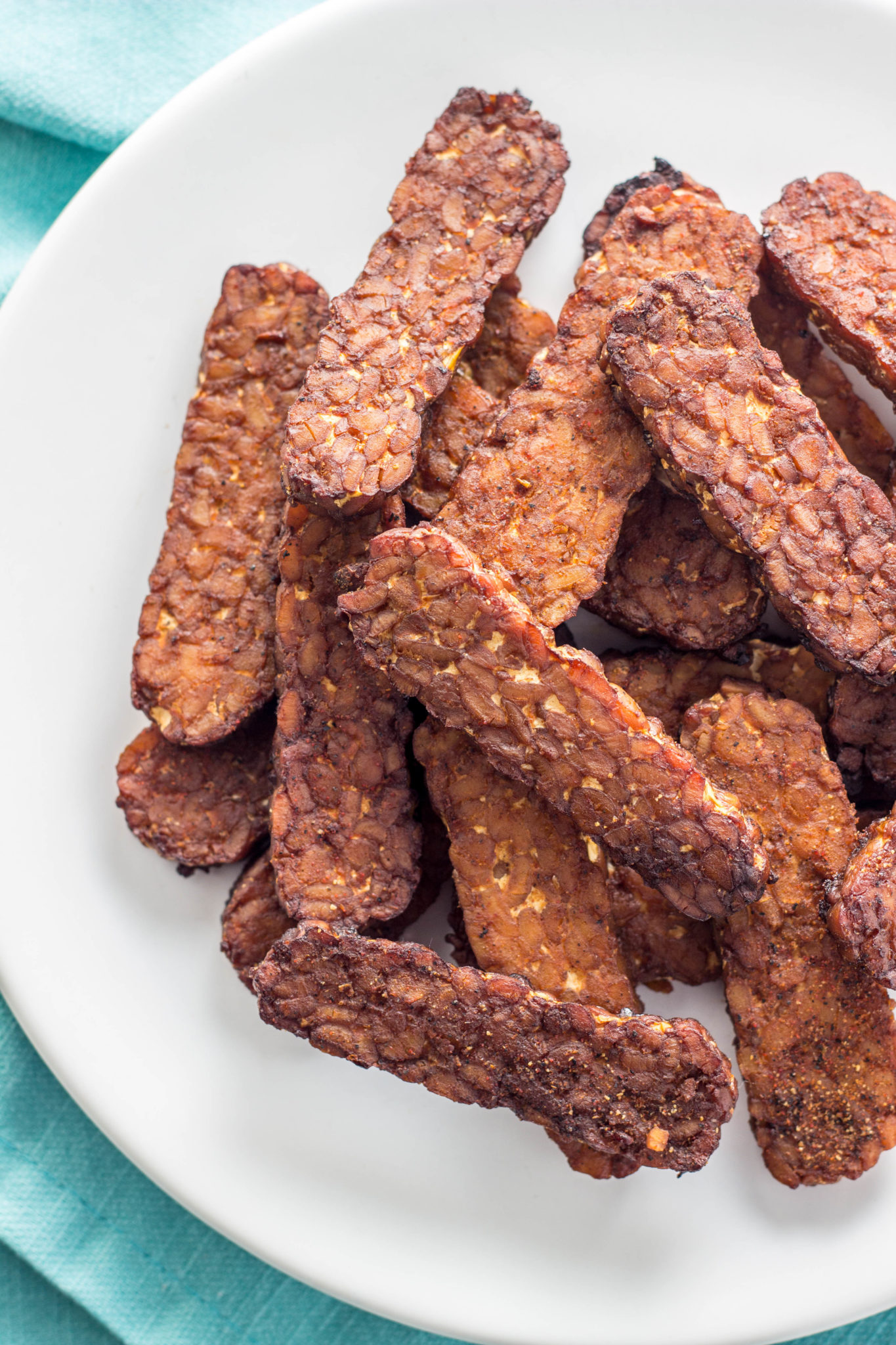 Close up of Tempeh Bacon on a white  plate. 