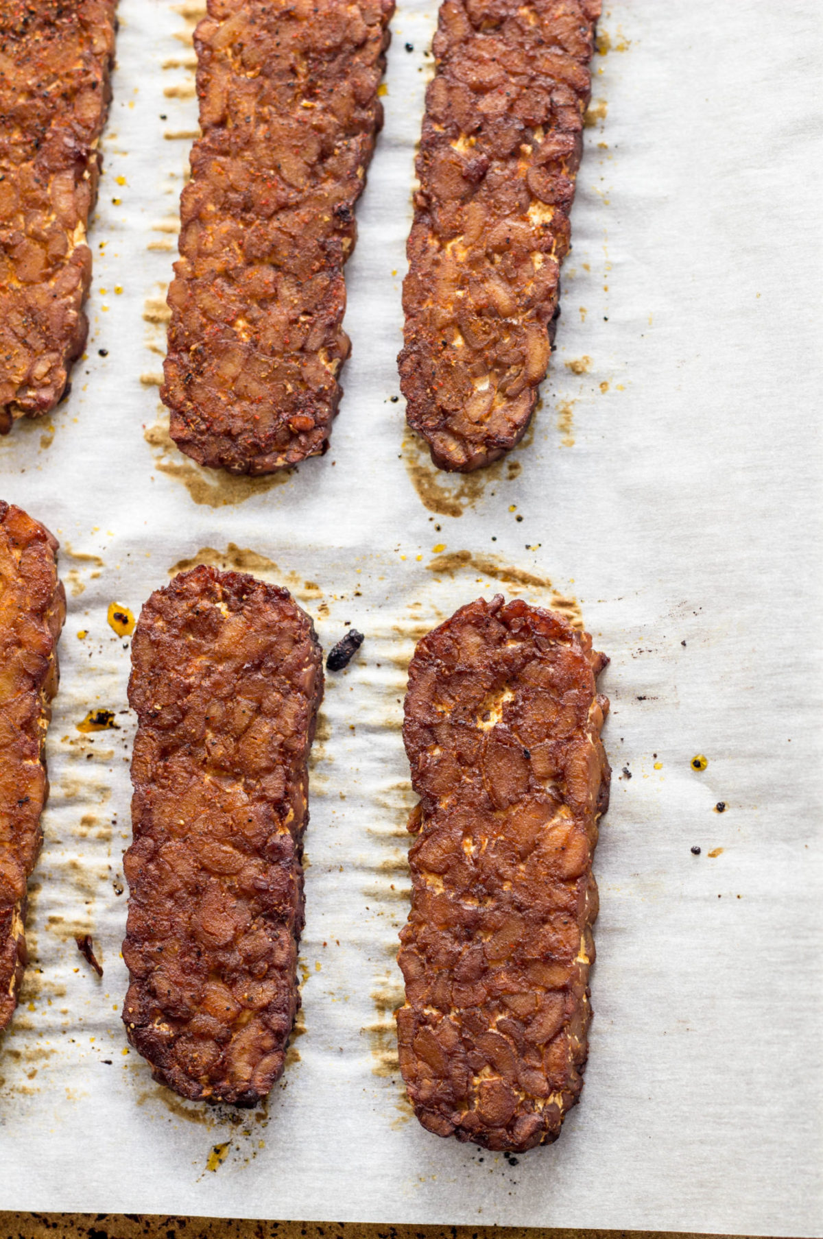 Tempeh Bacon on a parchment lined baking sheet. 