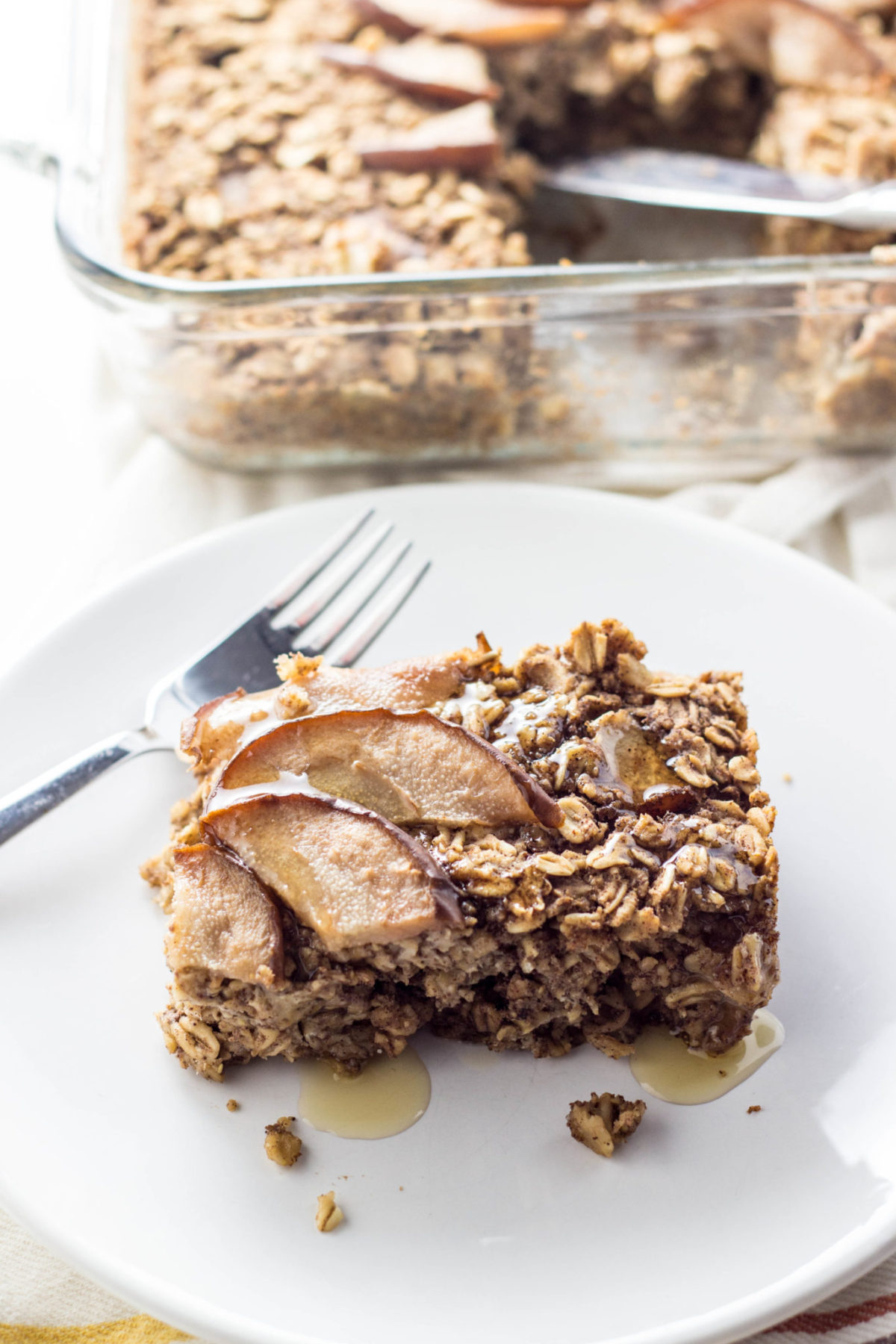 Side view of a serving of Cinnamon Pear Baked Oatmeal on a white plate. 