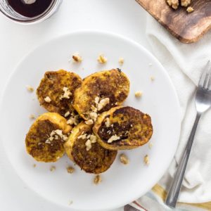 Top view of Vegan Pumpkin Chia French Toast topped with chopped walnuts on a white plate.