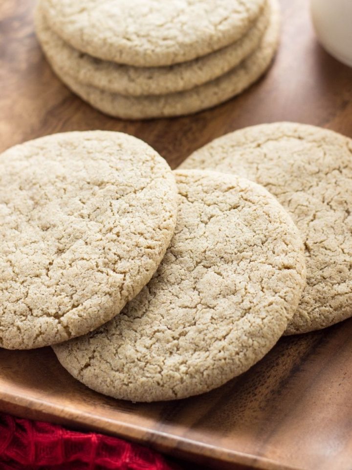 Close up side view of three Vanilla Cardamom Sugar cookies on a wooden plate.