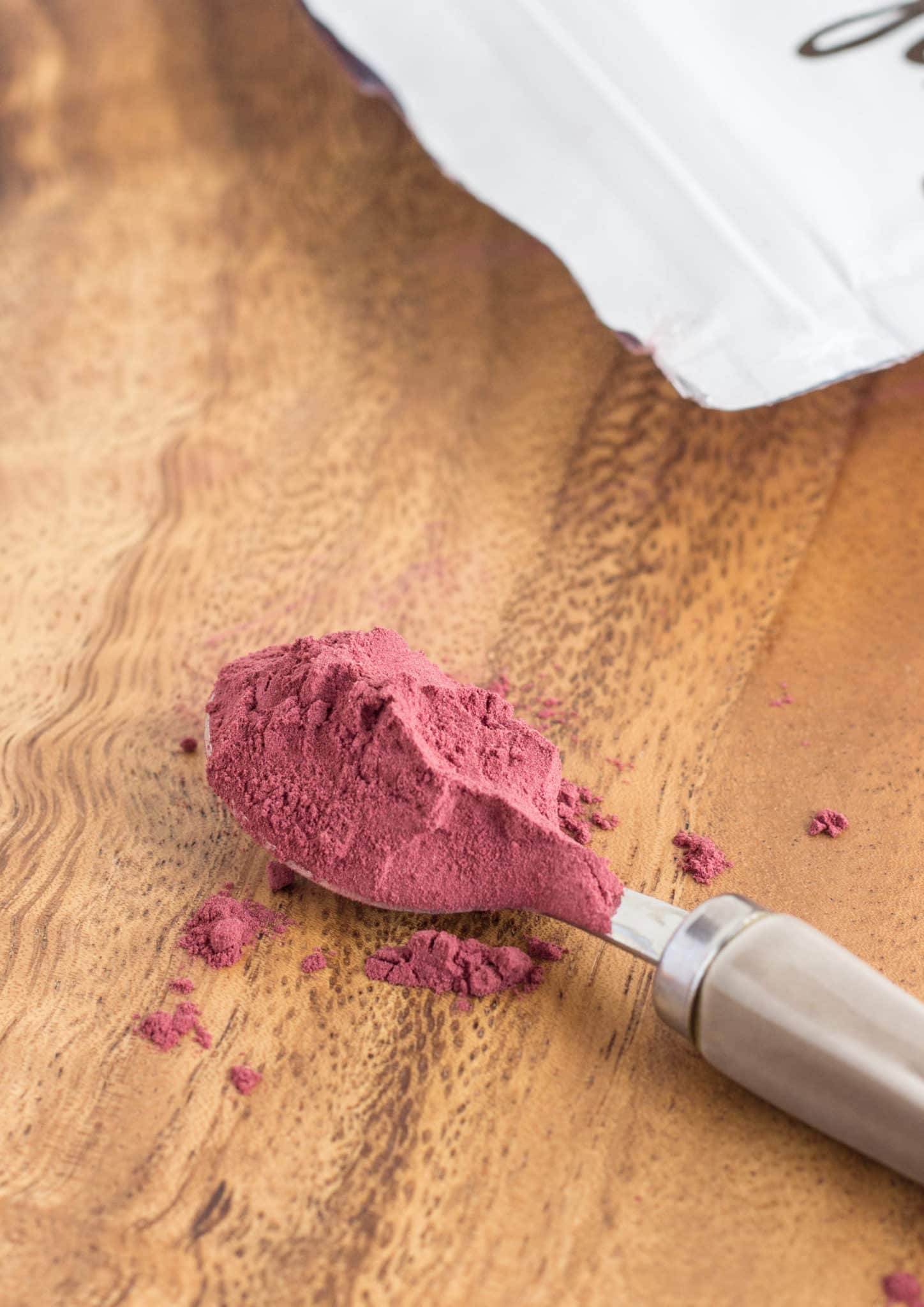 Close up of a spoon of beetroot powder.