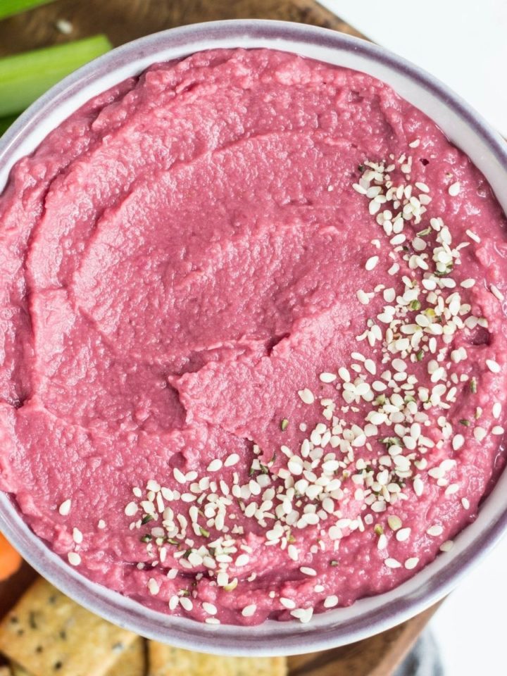 Close up top view of 5 Minute Beetroot Bean Dip with hemp seeds sprinkled around the edge.