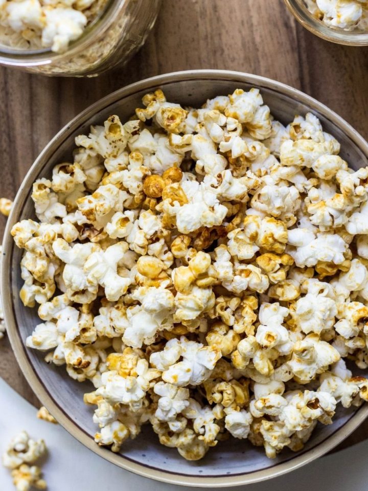 Top view of a bowl of Vegan Maple Kettle Corn on a wooden cutting board.