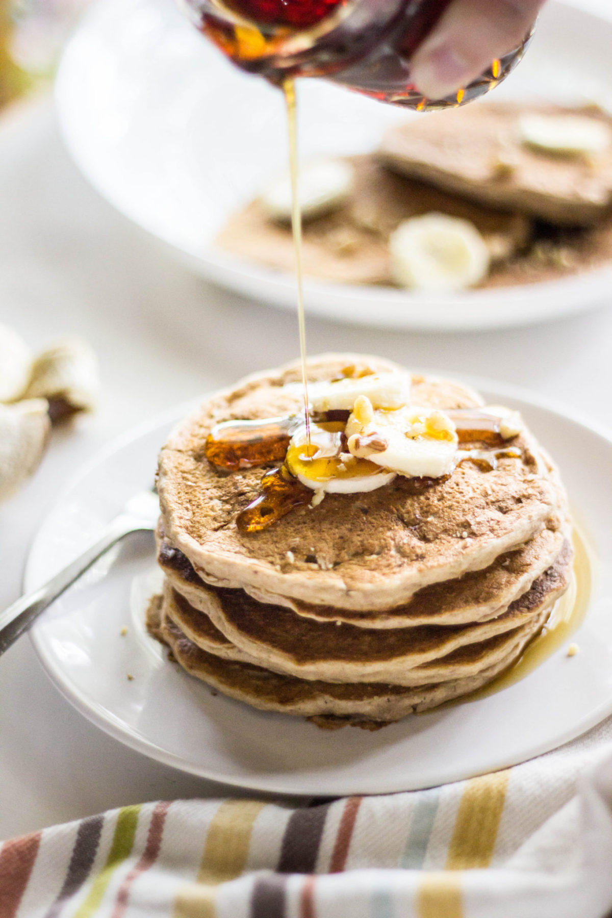 Maple syrup being drizzled on a stack of pancakes, 