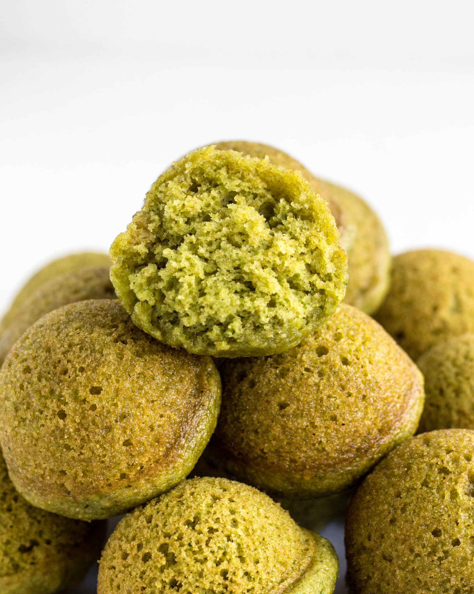 Close up of the interior of a Baked Spinach Doughnut Hole on a stack of doughnut holes.