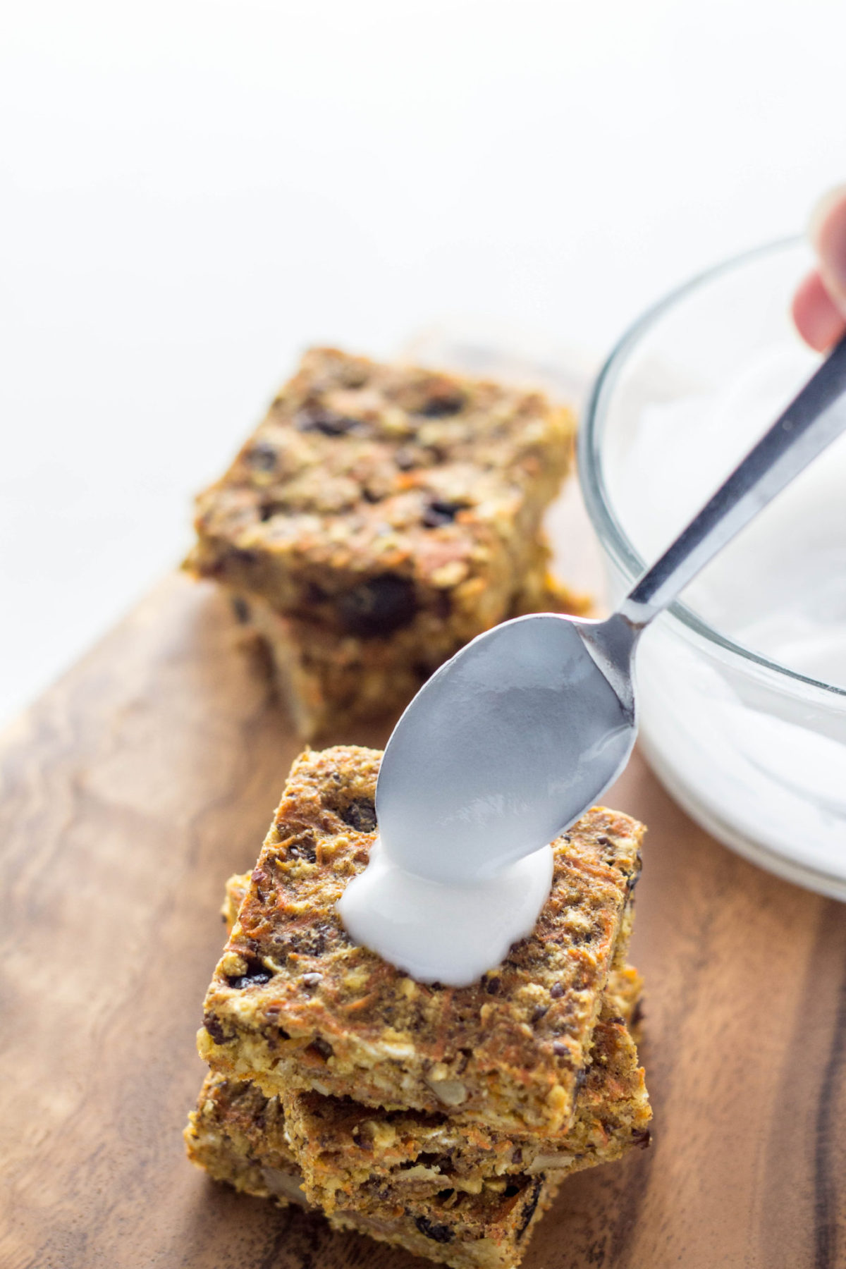 Spoon adding glaze to Carrot Cake Oat Square.