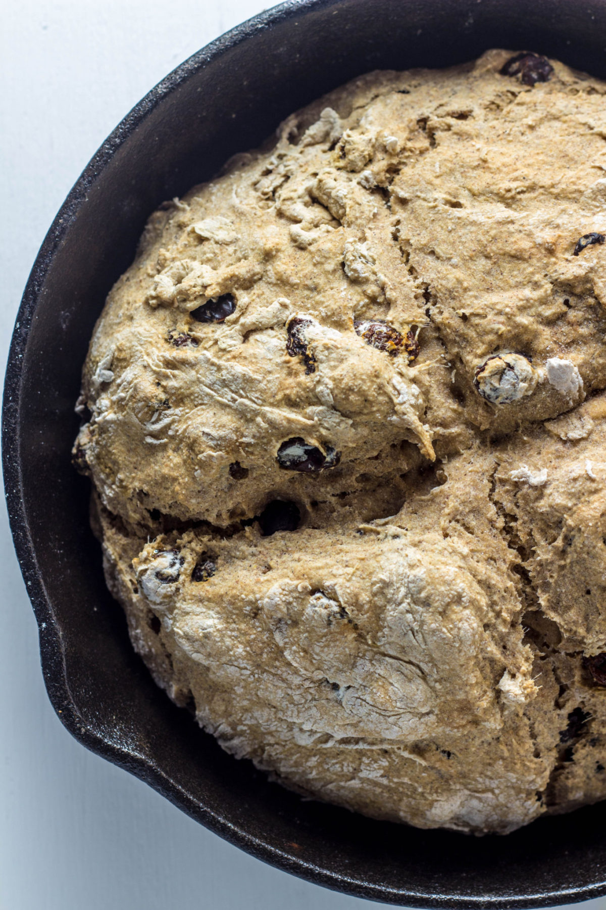 Close up view of Cinnamon Raisin Soda Bread  in a cast iron skillet. 