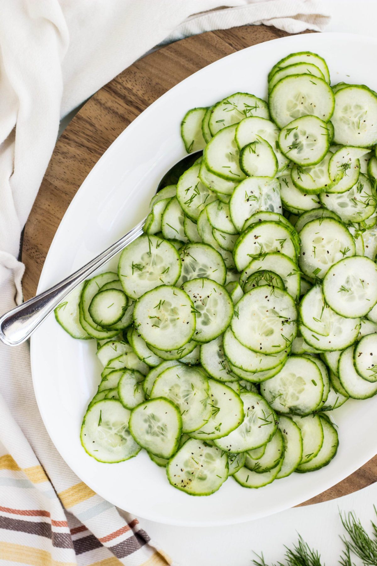 Closer image of cucumber salad on white serving plate.
