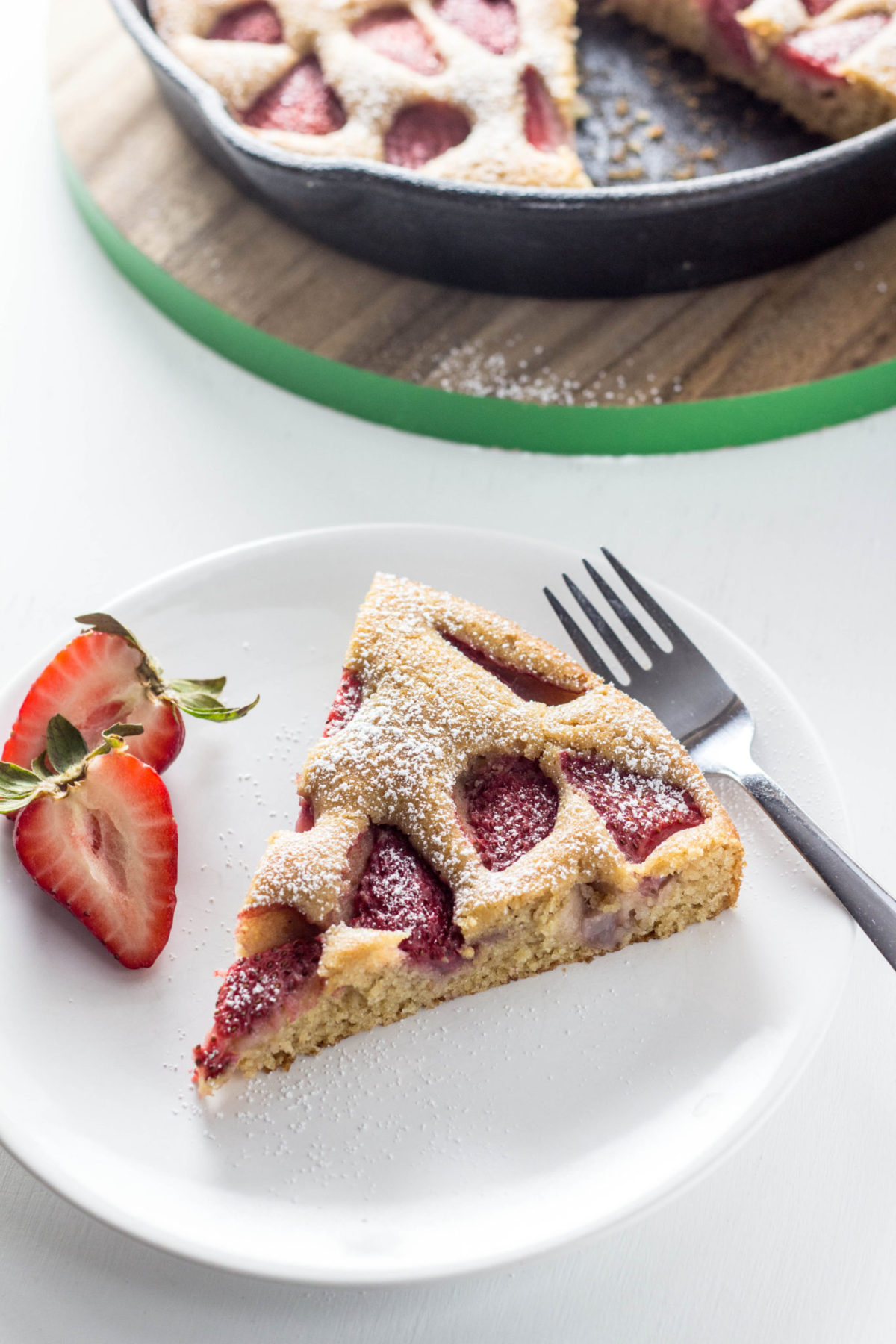 Side view of Berry Skillet Cake on a white plate.