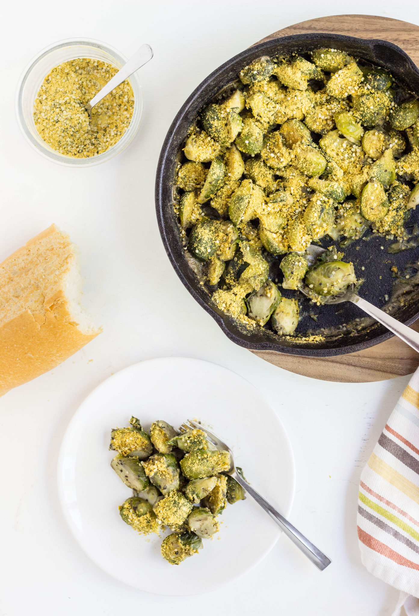 Over head view of Vegan Brussels sprouts Gratin in a cast iron skillet and served on a plate. 