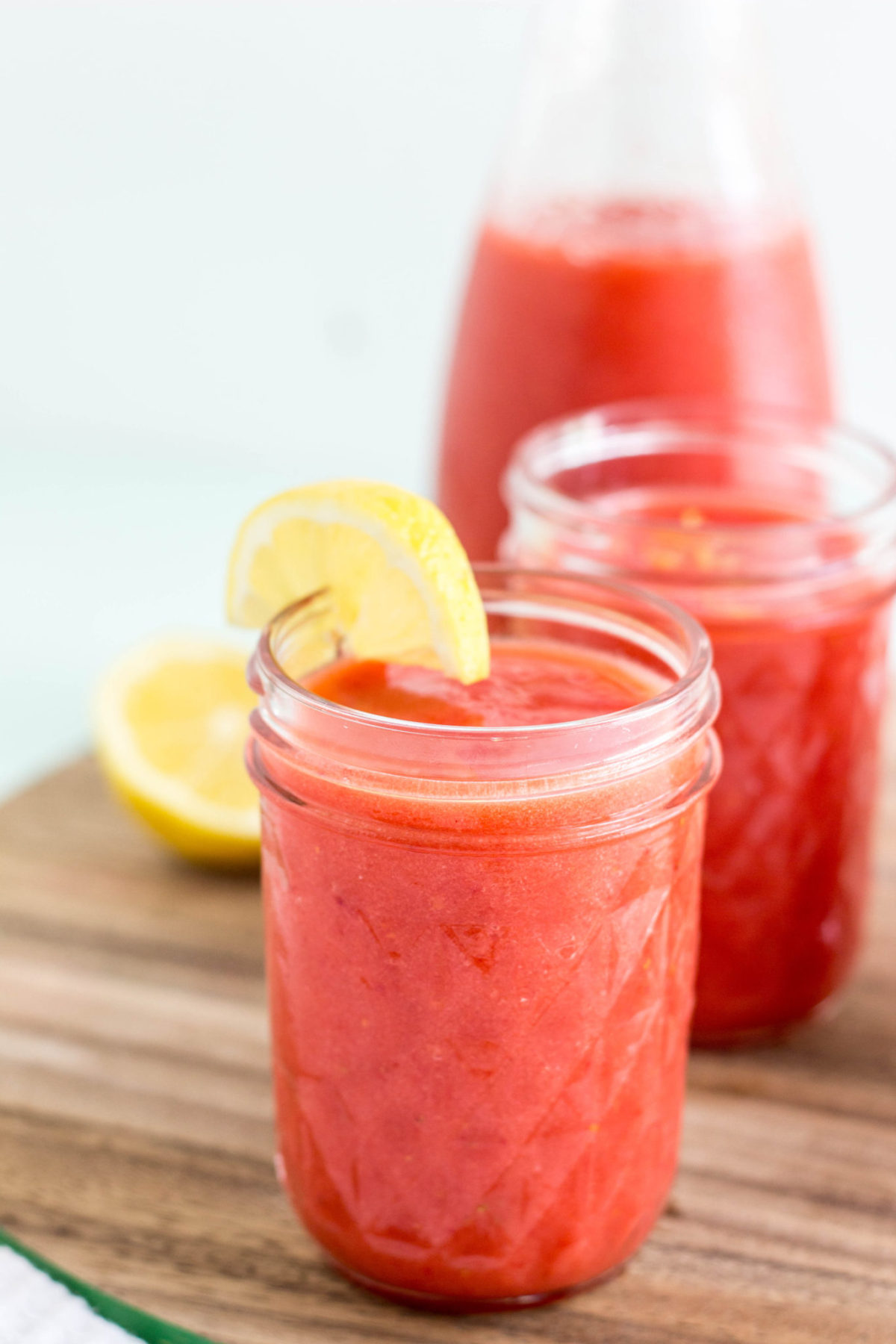 Close up side view of a glass of Frozen Strawberry Lemonade. 