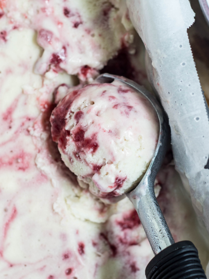 Close up of Vegan Strawberry Swirl Coconut Ice Cream in an ice cream scoop.