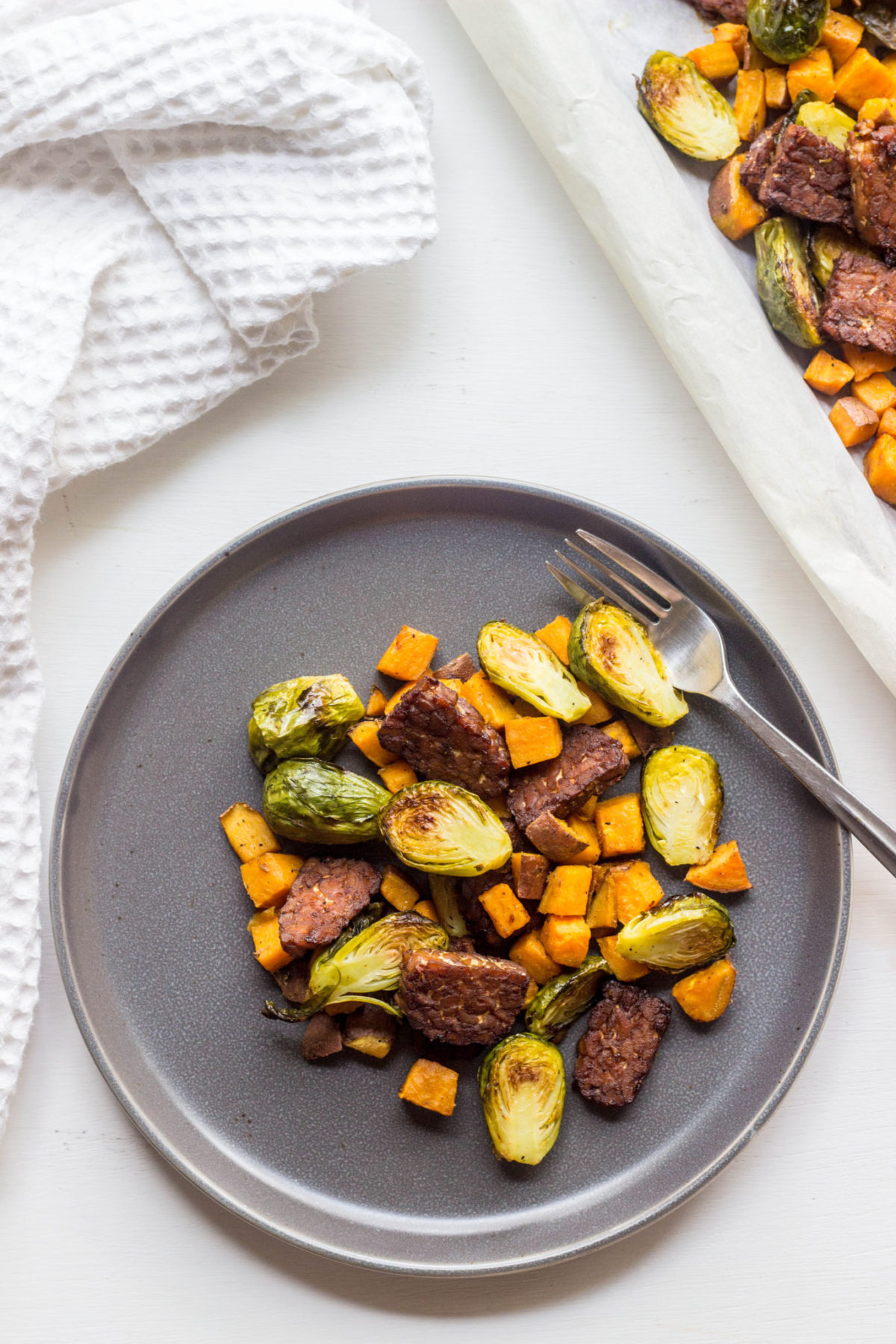 Brussels Sprout Tempeh Sheet Pan Hash on a gray plate, top view. 