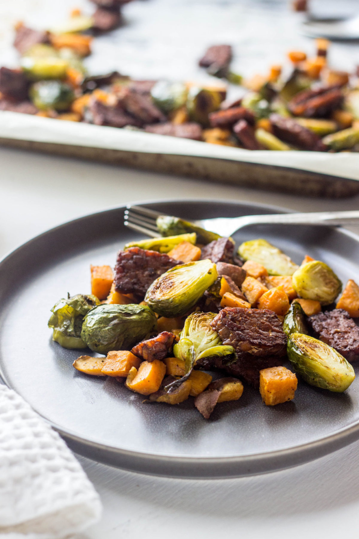 Brussels Sprout Tempeh Sheet Pan Hash on a gray plate, side view