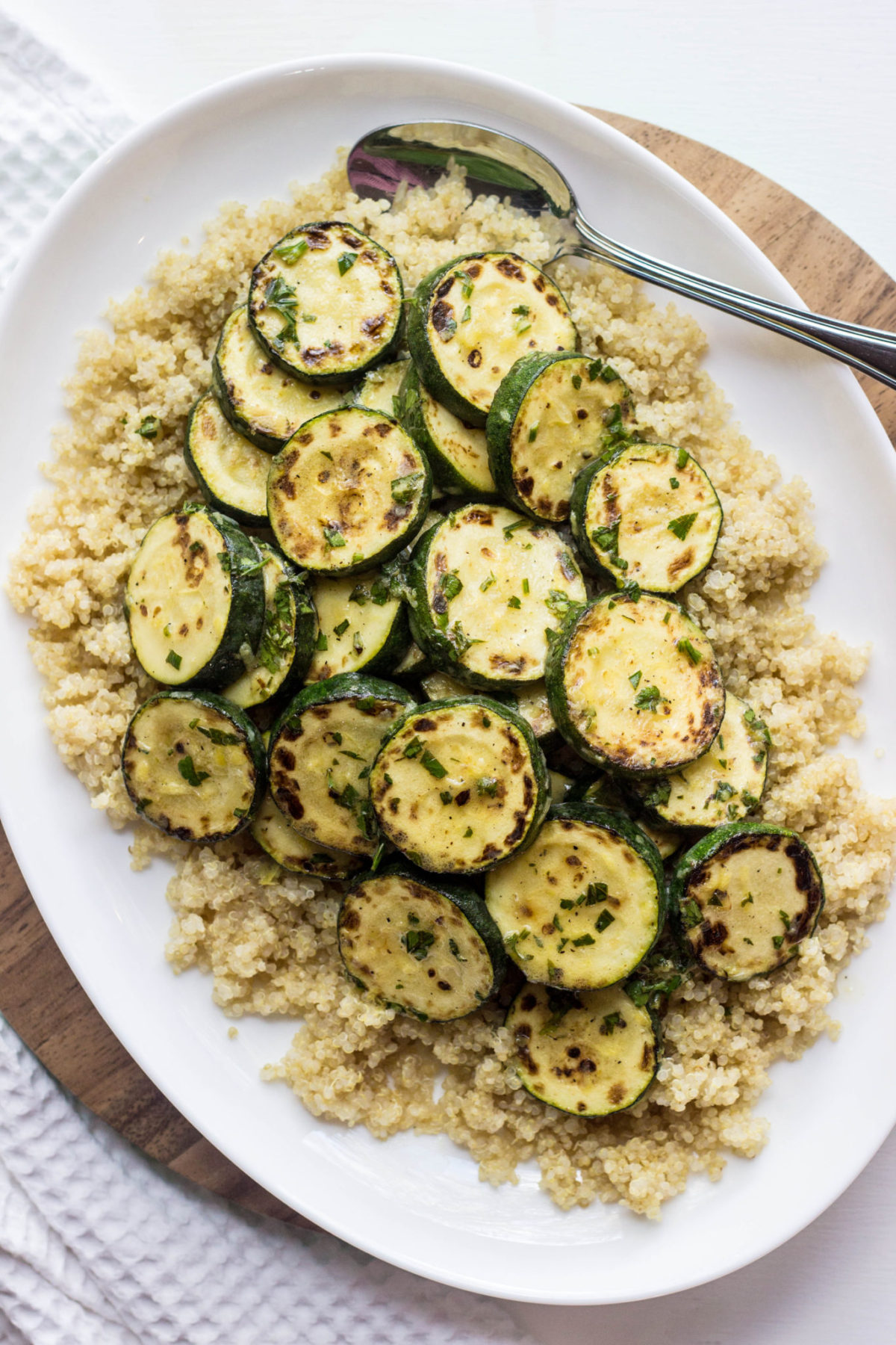 Charred Lemony Zucchini and Quinoa on a white serving platter, top view. 