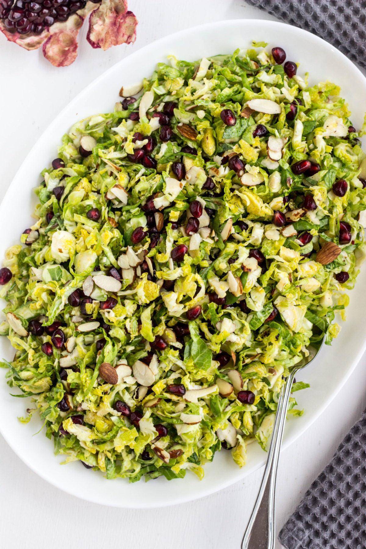 Top view of Brussels Sprout Pomegranate Salad on a white serving plate.  