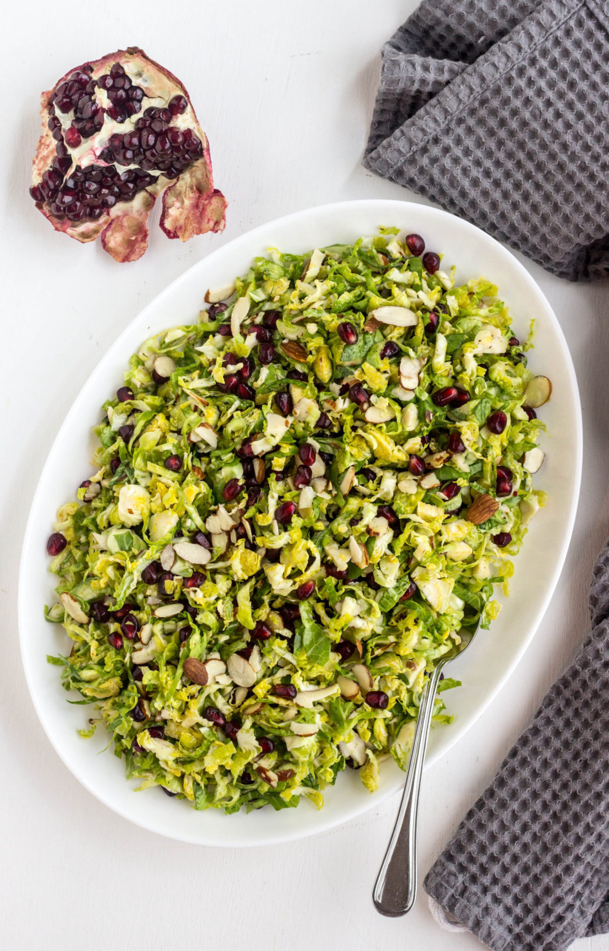 Top view of Brussels Sprouts Pomegranate Salad on a white plate. 