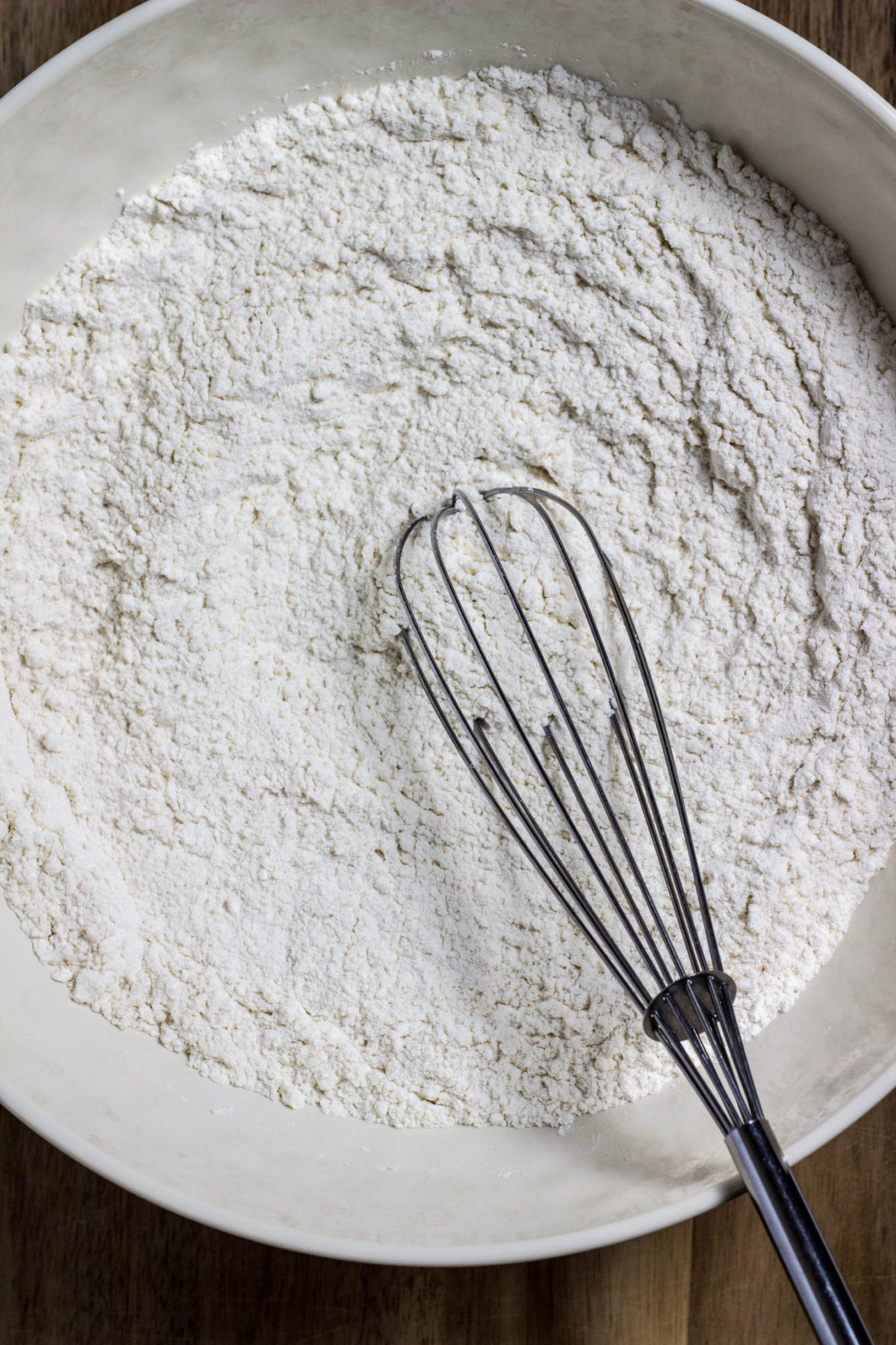 A large bowl with flour and a whisk to make flatbread.  