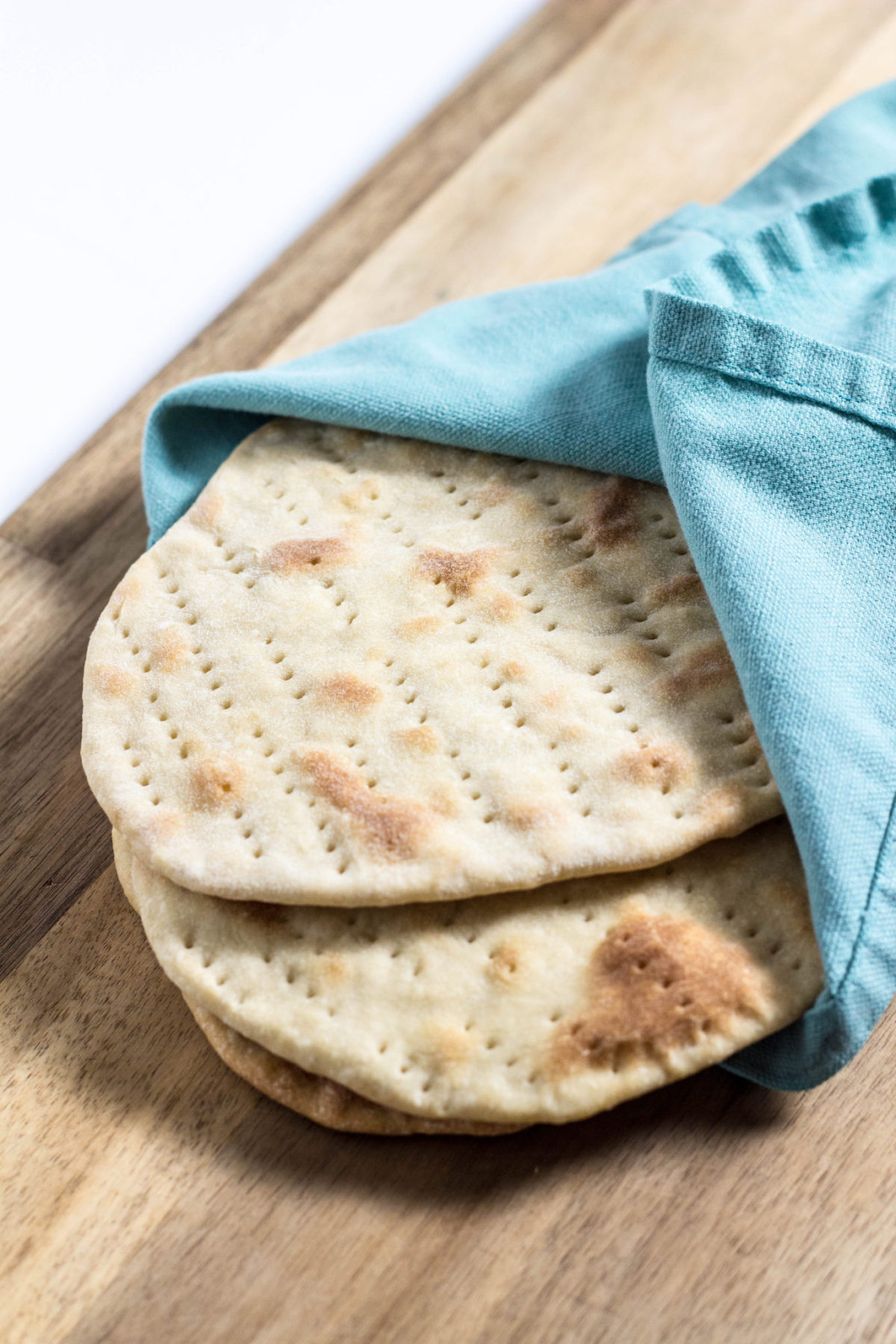 A stack of Easy Flatbread wrapped in a light blue towel. 