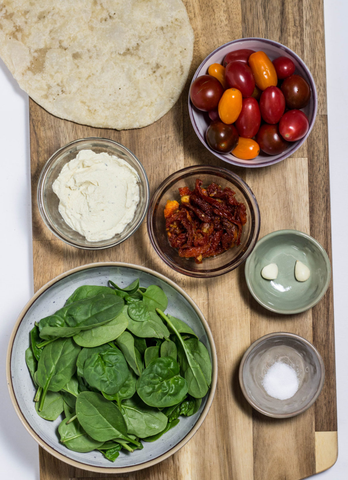 Ingredients for Vegan Tomato Flatbread on a wooden cutting board.