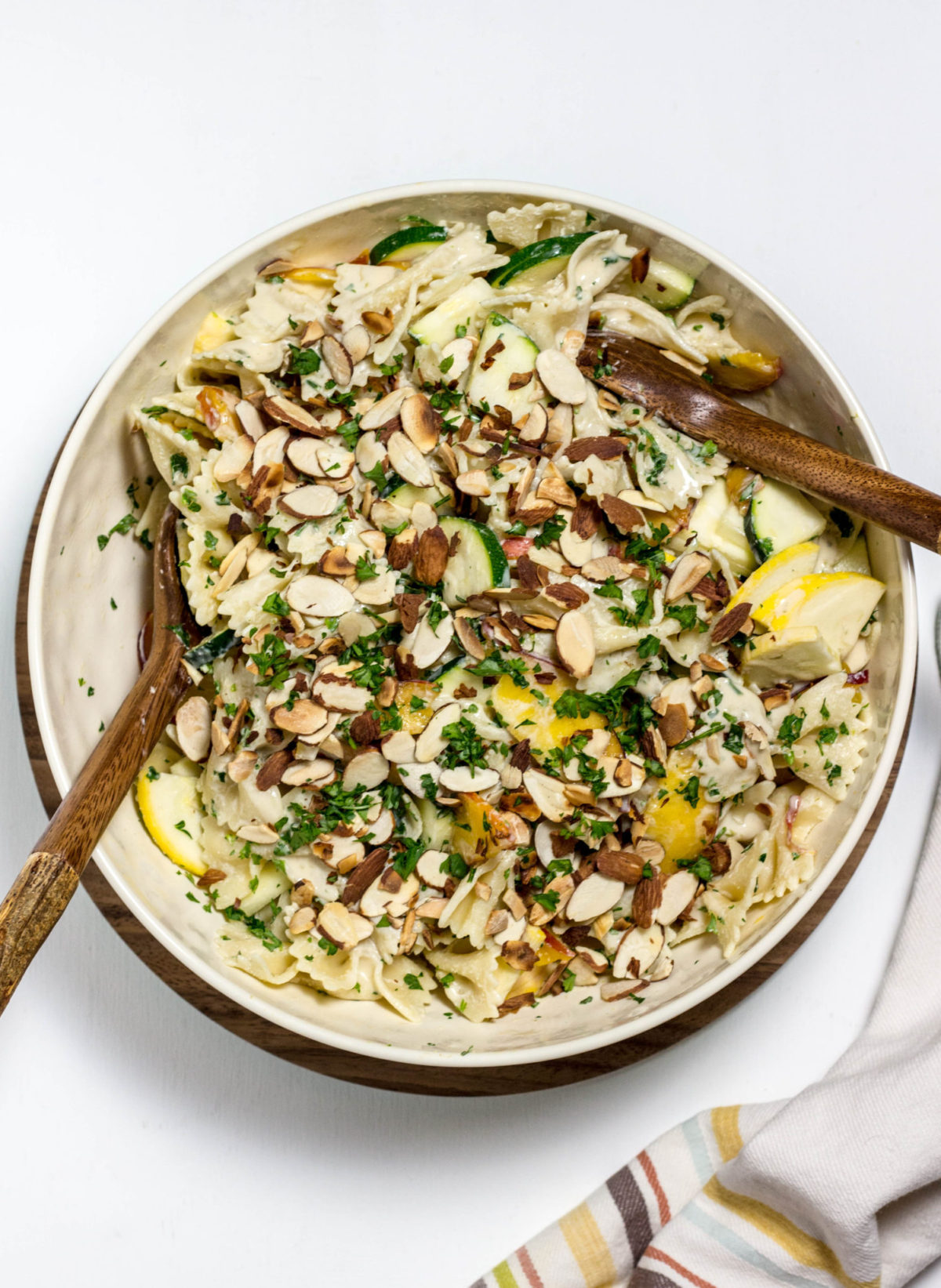 Overhead shot of a large bowl with Nectarine Summer Squash Pasta Salad with almond slices on top. 