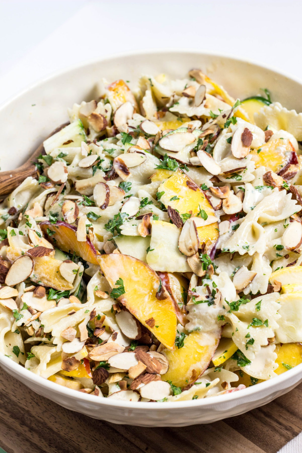 Close up side view of Nectarine Summer Squash Pasta Salad in a large bowl. 